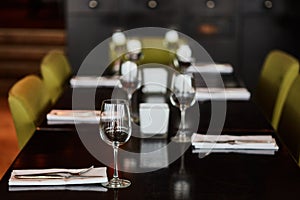 Dining table served with glasses, forks and knifes
