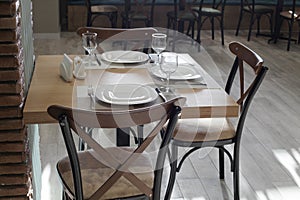 Dining table served with plates, glasses, forks and knives
