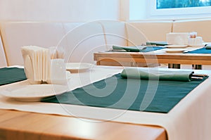 Dining table set up with cutlery in green napkins