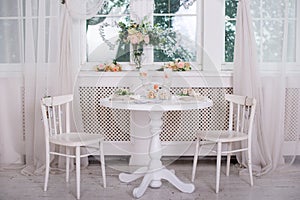 Dining table setting at Provence style, with candles, lavender, vintage crockery and cutlery, closeup.