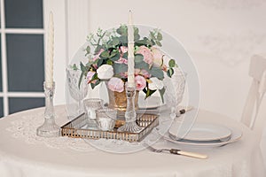 Dining table setting at Provence style, with candles, lavender, vintage crockery and cutlery, closeup.