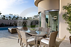 Dining Table By Swimming Pool On Patio