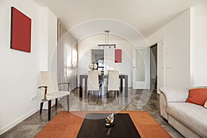 Dining table with upholstered chairs matching sofas in the living room of a ground floor home