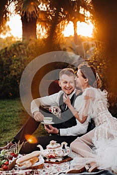 Dinner the Bridal couple at the picnic.A couple is relaxing at sunset in France.Bride and groom on a picnic in Provence