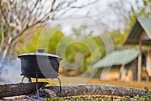 Dinner cooks in a large pot over an open fire