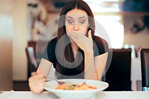 Woman Feeling Sick While Eating Bad Food in a Restaurant photo