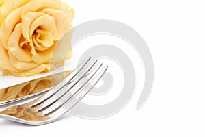 Dinner place setting. Knife and fork with yellow rose