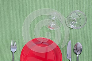 dinner place setting a red plate with silver fork