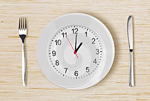 Dinner plate with clock face on wooden table