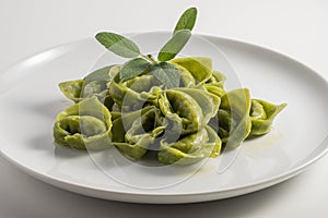 Dinner plate with green ravioli and sage