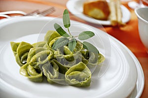 Dinner plate with green ravioli and sage