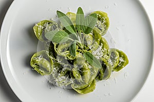 Dinner plate of green ravioli with sage and parmesan