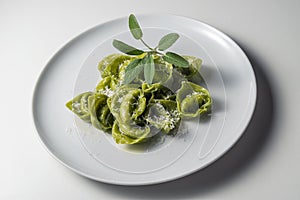 Dinner plate of green ravioli with sage and parmesan