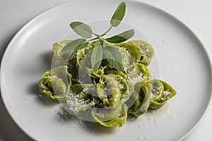 Dinner plate of green ravioli with sage and parmesan