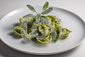 Dinner plate of green ravioli with sage and parmesan