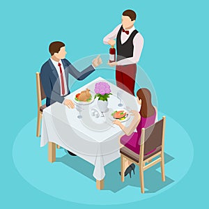 Dinner In Restaurant. Young couple having dinner in a restaurant. Man and woman sitting at the table, the waiter takes