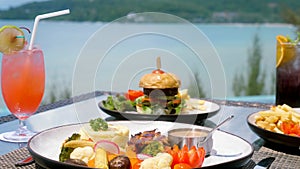 Dinner with sea view. Fine dining food in outdoor restaurant, poolside table with fresh food. Lunch or breakfast in