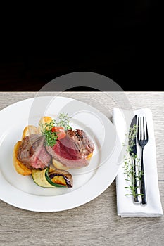 A dinner setting: Juicy grilled bbq steaks with fresh herbs, potato