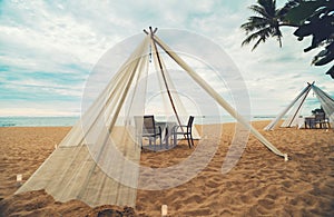 Dinner table on the beach at seaside with sea and blue sky background