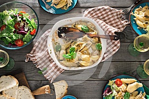 Dinner table with pasta, fresh salad and white wine