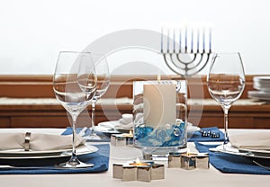 Dinner table setting decorated for Hanukkah. Traditional Jewish holidays home celebrations decor