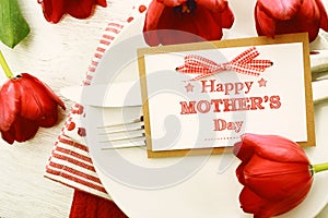 Dinner table setting with Mothers day message card and tulips