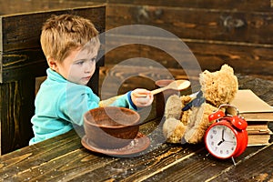 Dinner time. Little boy and teddy bear have dinner together. Child feed toy with healthy dinner. Dinner with friend. Eat