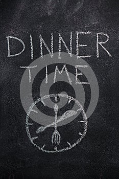 Dinner time text with clock on black chalkboard