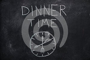 Dinner time text with clock on black chalkboard