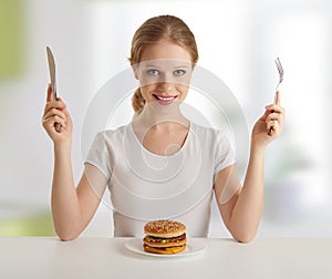 Dinner time.woman and knife, fork, hamburger