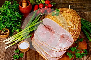 Dinning table with whole baked and sliced ham, vegetables and spice