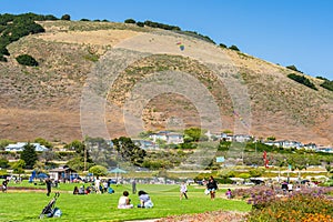 Dinosaur Caves Park, playground and walking trail, grassy lawn, green hills, and Ocean view. Shell Beach, California