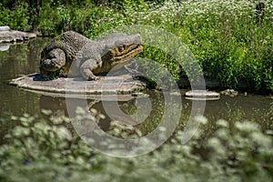 Dinosaur sculpture by the pond