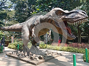 a dinosaur statue in the middle of a scary city