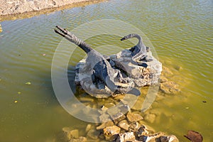 Dinosaurs statues on the pond in Geosfera park in Jaworzno