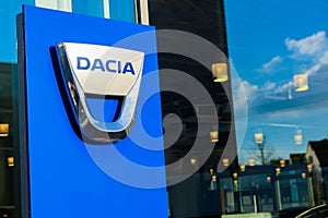 Isolated lettering of rumanian automobile manufacturer Dacia against window of car dealer