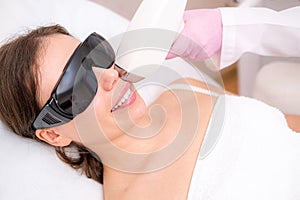 Diode laser hair removal, Beautician removes hair on beautiful female face, Hair removal for smooth skin, laser photo