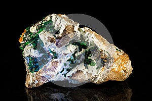 Dioptase in parent rock in front of black