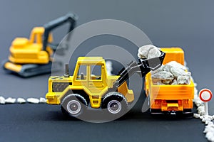 Diorama road construction with yellow construction machinery models