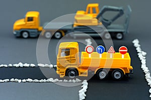 Diorama road construction with yellow construction machinery models