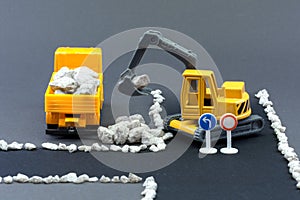 Diorama road construction with yellow construction machinery models