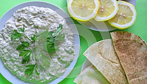 Dip Baba ghanoush with pita bread and fresh lemon on green background