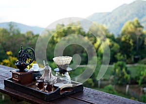 The dip coffee with the coffee dripper maker set on a wooden table photo