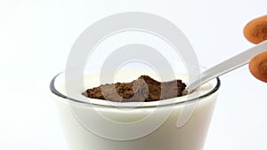Dip a spoon containing cocoa powder into a glass filled with milk. Experimental concept of water-repellent