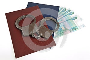 Diplomas of higher education and money with handcuffs isolated
