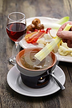 dipping celery. Bagna cauda(Italian Piedmont cuisine) is a hot dip made from garlic and anchovies. photo