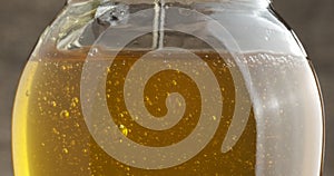 Dipping honey stick into the jar of honey.