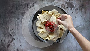 Dipping a tortilla chip in salsa