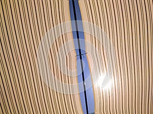 direct sunlight shining through textile stripped fabric tent on bright sunny day at the beach on summer sun