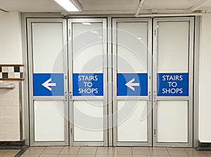 Direction arrow sign to shops from stairs at shopping mall